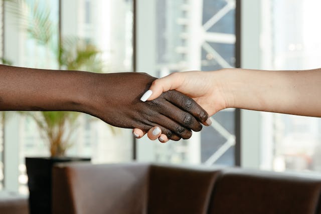 multiracial-women-shaking-hands-in-modern-office